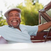 Smiling older man driving a classic car