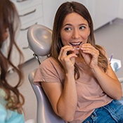 Woman smiling while putting on clear aligner