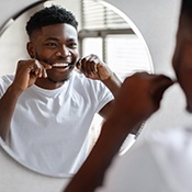 Man smiling while flossing his teeth