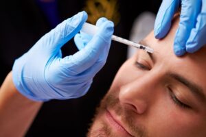 Man receiving BOTOX between his eyebrows