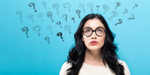 Woman looking up at question-mark graphics above her head